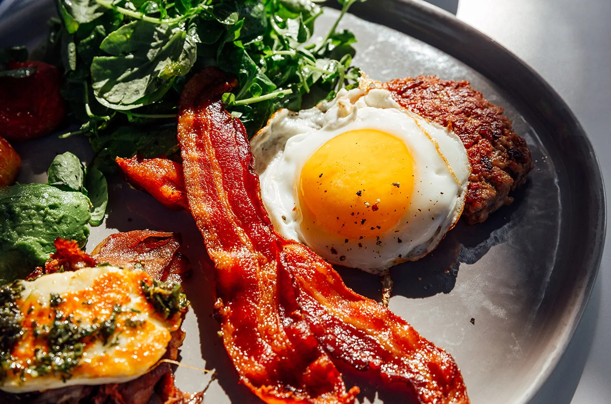 crispy bacon with fried eggs and greens, a delicious keto meal option